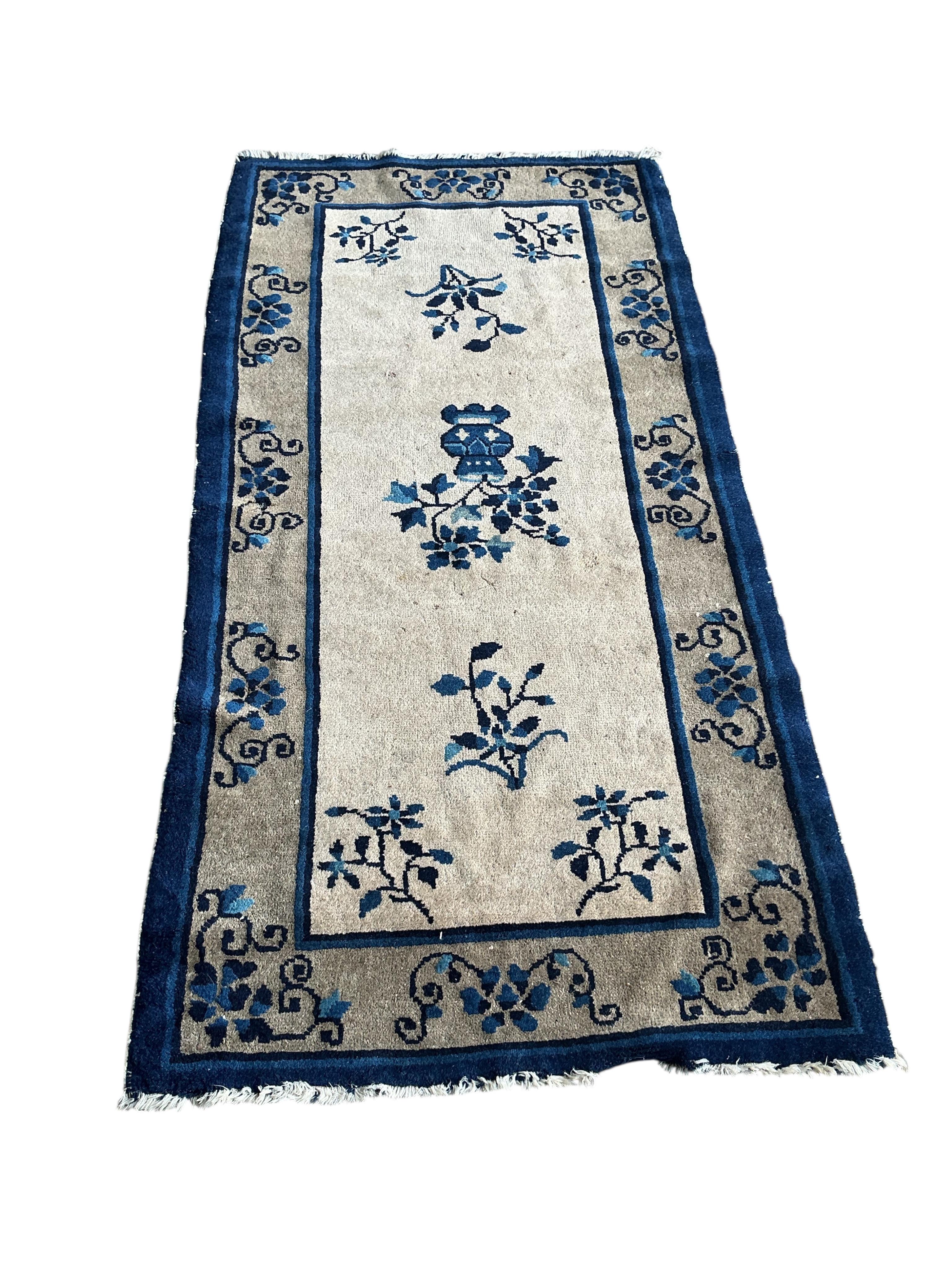 A Chinese fawn ground floral rug, 160 x 78cm